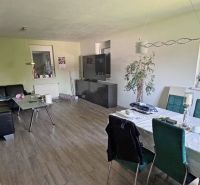 Rodinný dom v Dunajskej Lužnej  - Obývacia izba s pohovkou, jedálenským stolom a podlahou s dreveným dekorom v rodinnom dome.