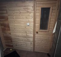 Rodinný dom v Dunajskej Lužnej  - Drevené obloženie a dvere sauny v rodinnom dome s dlaždenou podlahou.