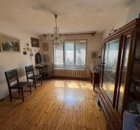 Krásny pozemok so starším domom Na Riviére, vhodný aj na investíciu  - Izba v rodinnom dome s dreveným dekorom, vintage nábytkom a množstvom obrazov na stenách.