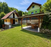 Záhrada s murovanou chatkou a výhľadom, Považská Bystrica -Klučina - Chata na Klučine v Považskej Bystrici s altánkom a trávnikom, obklopená zeleňou.