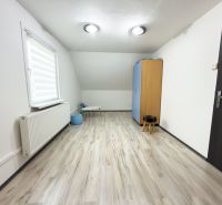 Na predaj rodinný dom - Makov - Izba v rodinnom dome s podlahou s dreveným dekorom a jednoduchým nábytkom.