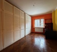 Predaj 3 izbový byt, 86 m2, Francisciho ul, Staré mesto, BAI . - Izba s oranžovou stenou, veľkou skriňou a podlahou s dreveným dekorom v 3-izbovom byte.