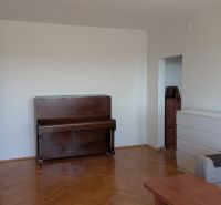 3 izbový byt v centre mesta na Štúrovej ulici s krásnym výhľadom - Obývacia izba s podlahou s dreveným dekorom, pianom a bielou komodou v 3-izbovom byte.