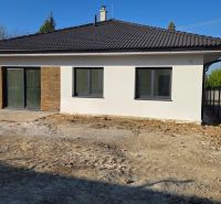 Bungalov v centre obce Cabaj Čápor, Wágnerova ulica, Dom č.1 - Rodinný dom v Cabaji-Čápore s bielou fasádou, kamennými detailmi a šikmou strechou.