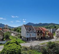 Prenájom Kancelárie 110 m² v centre Ružomberka - Pohľad na budovy a ulice v Ružomberku, s zelenými kopcami v pozadí.