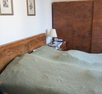 Radový domček na Zobore s výhľadom na mesto, Ružová ulica, garáž - Spálňa v rodinnom dome s dreveným nábytkom a zelenou posteľnou prikrývkou.