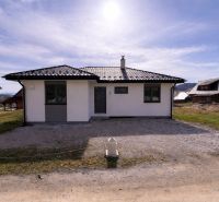 Novostavba v blízkosti  Liptovskej Mary – bungalov - Rodinný dom v Ižipovciach s jednoduchou fasádou a šikmou strechou na slnečnom pozemku.
