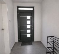 Novostavba v blízkosti  Liptovskej Mary – bungalov - V interiéri vidíme vchodové dvere, biele steny a dlažbu s kľúčmi na podlahe.