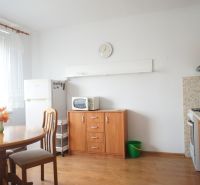 Prenájom 1-izb. bytu, Skýcovská ul., Topoľčany - Kuchyňa v 1-izbovom byte s okrúhlym stolom a podlahou s dreveným dekorom.