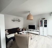 NA PRENÁJOM Pekný 2 izbový byt v Centre Pezinka 700,- EUR - Obývacia izba v 2-izbovom byte s podlahou s dreveným dekorom a pohodlným nábytkom.