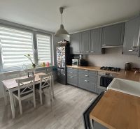 NA PRENÁJOM Pekný 2 izbový byt v Centre Pezinka 700,- EUR - Kuchyňa v 2-izbovom byte so sivými skrinkami a podlahou s dreveným dekorom.