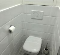 NA PRENÁJOM Pekný 2 izbový byt v Centre Pezinka 700,- EUR - Toaleta s bielymi dlaždicami a podlahou s dreveným dekorom v 2-izbovom byte.