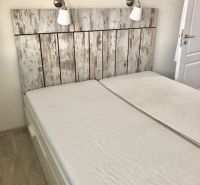NA PRENÁJOM Pekný 2 izbový byt v Centre Pezinka 700,- EUR - Dvojlôžko v 2-izbovom byte so stene s dreveným dekorom a lampami.