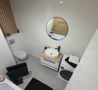 : 1,5-izbový byt, Košice – Juh, loggia, 43 m² - Kúpeľňa v 2-izbovom byte so zrkadlom, práčkou a umývadlom na drevenom pulte.