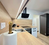 : 1,5-izbový byt, Košice – Juh, loggia, 43 m² - Kuchyňa s podlahou s dreveným dekorom, indukčná varná doska a elegantná digestor.