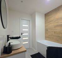 : 1,5-izbový byt, Košice – Juh, loggia, 43 m² - Kúpeľňa v 2-izbovom byte s vaňou a podlahou s dreveným dekorom.