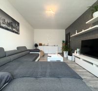 Na predaj: 4 izb.byt + BALKON + PIVNICA - Obývačka s veľkou sedačkou a televíziou, podlaha s dreveným dekorom. 4-izbový byt.