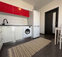 Na predaj: 4 izb.byt + BALKON + PIVNICA - Kuchyňa v 4-izbovom byte s bielymi skrinkami, práčkou a podlahou s dreveným dekorom.