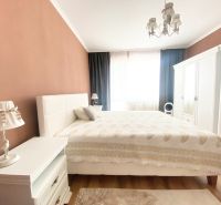 NA PRENÁJOM UNIKÁTNY RUSTIKÁLNY 2-IZBOVÝ BYT, STARÉ MESTO - Spálňa v 2-izbovom byte s manželskou posteľou, bielym nábytkom a podlahou s dreveným dekorom.