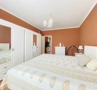 NA PRENÁJOM UNIKÁTNY RUSTIKÁLNY 2-IZBOVÝ BYT, STARÉ MESTO - Spálňa v 2-izbovom byte s bielym nábytkom a posteľou na podlahe s dreveným dekorom.