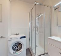 | Zariadený 1,5 izbový byt | 35m² | SLNEČNICE - Kúpeľňa v 2-izbovom byte so sprchovacím kútom, práčkou a umývadlom s úložným priestorom.