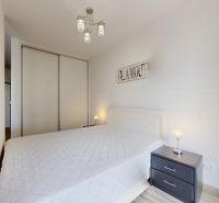 | Zariadený 1,5 izbový byt | 35m² | SLNEČNICE - Spálňa s manželskou posteľou, nočnými stolíkmi a vstavanou skriňou v 2-izbovom byte.