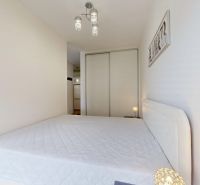 | Zariadený 1,5 izbový byt | 35m² | SLNEČNICE - Svetlá spálňa s manželskou posteľou a vstavanou skriňou v 2-izbovom byte.