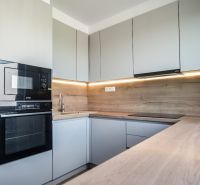 Bývanie pod zámkom - 3i byt 76m2, rekonštrukcia,  Smolenice - Kuchyňa v 3-izbovom byte s podlahou s dreveným dekorom a vstavanými spotrebičmi.