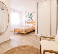 Predaj- Apartmány - La Manga del Mar Menor- Španielsko  - Interiér Rekreačného apartmánu s posteľou, zrkadlom a podlahou s dreveným dekorom.