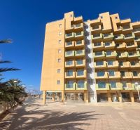 Predaj- Apartmány - La Manga del Mar Menor- Španielsko  - Rekreačný apartmán v La Manga del Mar Menor s palmami a jasnou oblohou.