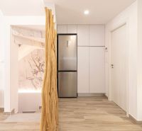 Predaj- Apartmány - La Manga del Mar Menor- Španielsko  - Interiér rekreačného apartmánu s kuchynskými skrinkami, chladničkou a podlahou s dreveným dekorom.