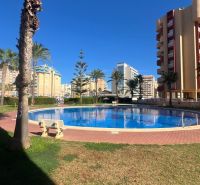Predaj- Apartmány - La Manga del Mar Menor- Španielsko  - Bazén obklopený zeleňou a palmovými stromami v La Manga del Mar Menor predstavuje rekreačný apartmán.
