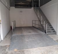 Na prenájom skladové priestory od 25 m2 Trnava Coburgova - Sklady a haly s kovovou plošinou a schodiskom, biele steny, industriálny vzhľad.