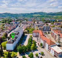 Charizmatický 2-izbový byt na bývanie alebo prenájom | Mudroňova ulica - Púchov, Mudroňova ulica: letecký pohľad na obytné a komerčné budovy v okolí.