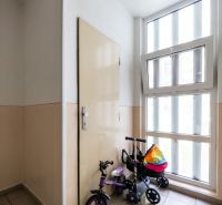 Štýlový 3-izbový byt po kompletnej rekonštrukcii – stačí sa nasťahovať - Chodba s detským bicyklom pri okne a dverách v 3-izbovom byte.