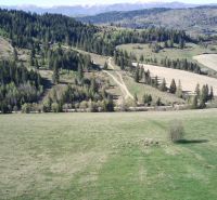 Čierny Balog – 2.730 INVESTIČNÝ pozemok v podiele 1/1 - Poľnohospodárske a lesné pozemky v Čiernom Balogu s kopcami, lesmi a cestou v krajine.