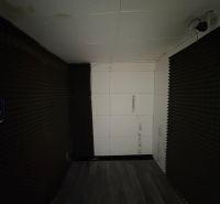PREDAJ – Garáž na predaj v meste Galanta za kaštieľom  - Interiér s tmavými stenami a podlahou s dreveným dekorom v garáži.