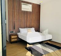 VILA AURA – FREE HOLD VLASTNÍCTVO S PRIAMYM VÝHĽADOM NA SOPKU AGUNG - Spálňa v rodinnom dome so vzorovanou stenou, ventilátorom, kobercom a podlahou s dreveným dekorom.
