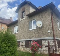 Rodinný dom zo záhradou - Rudná - Rodinný dom v Rudnej s textúrovanou fasádou, zeleným plotom a kvetmi v záhrade.