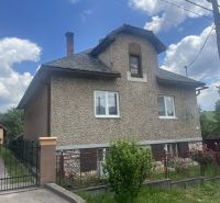 Rodinný dom zo záhradou - Rudná - Rodinný dom v Rudnej s dvojpodlažnou fasádou, oploteným pozemkom a modrou oblohou.