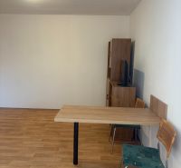 ZARIADENÁ GARSONKA NA SEVERE - Garsónka s podlahou s dreveným dekorom, stolom a stoličkami.