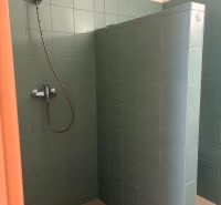ZARIADENÁ GARSONKA NA SEVERE - Sprchovací kút s tyrkysovými obkladačkami v garsónke.