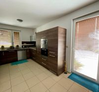 PREDAJ - 3 izbový rodinný dom Trnovec nad Váhom - Kuchyňa v rodinnom dome s tmavým dekorom skriniek a dlažbou.