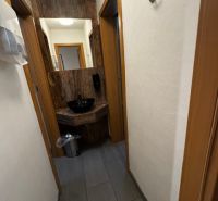 Podnikateľské priestory v  širšom centra mesta Nové Zámky, prízemie - Chodba obchodných priestorov s tmavou podlahou a bielymi stenami.
