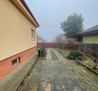 PREDAJ - 4-izbový rodinný dom s garážou, tichá lokalita, Svätoplukovo - Rodinný dom v Svätoplukove s exteriérovou betónovou plochou a okolitou vegetáciou.