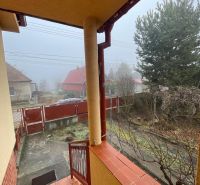 PREDAJ - 4-izbový rodinný dom s garážou, tichá lokalita, Svätoplukovo - Rodinný dom v Svätoplukove s vonkajšími schodmi a upravenou záhradou v hmlistom počasí.