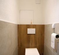 MODERNÝ  2-IZB.BYT PO KOMPLETNEJ REKONŠTRUKCII, UŽ LEN BÝVAŤ - Kúpeľňa v 2-izbovom byte s podlahou s dreveným dekorom a toaletou.