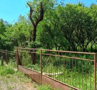 Rodinný dom, pozemok 4282m2 KĽAČNO okr. Prievidza, - Záhrada pri rodinnom dome v Kľačne, obklopená zeleňou a stromami za kovovým plotom.