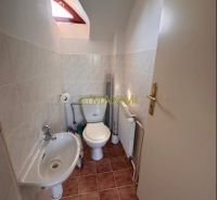 Rodinný dom v obci Kuchyňa - Kúpeľňa v rodinnom dome s WC, umývadlom a dlažbou v hnedých odtieňoch.