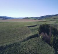 Čierny Balog – 338 m2 POĽNOHOSPODÁRSKY pozemok v 1/1 - Krajina v okolí Čierneho Balogu s poľnohospodárskymi a lesnými pozemkami, za jasného dňa.